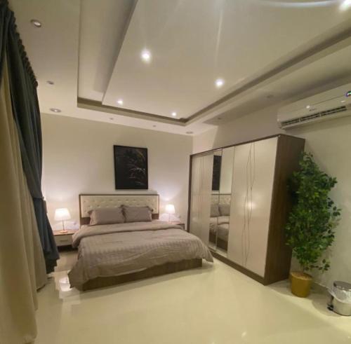 a bedroom with a bed and two lamps and a plant at شقق ارفلون دخـول ذاتي in Riyadh