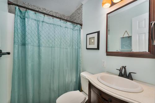 a bathroom with a sink and a shower curtain at 7039 - A Wave From It All by Resort Realty in Rodanthe