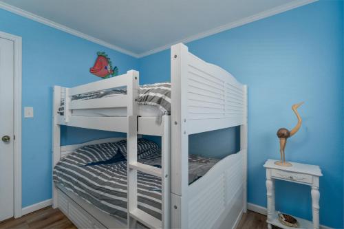 a white bunk bed in a room with blue walls at 7039 - A Wave From It All by Resort Realty in Rodanthe