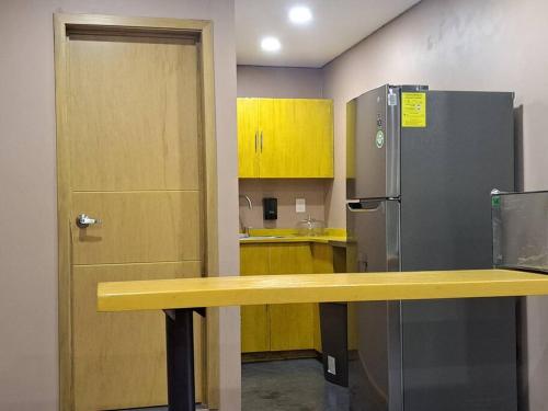 a kitchen with a yellow counter and a refrigerator at lugar para descansar210 in Fortín de las Flores