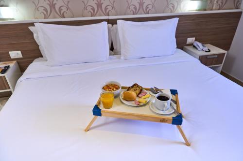 a tray of food on a bed with a breakfast at Foz Plaza Hotel in Foz do Iguaçu