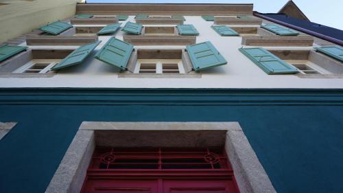 ウーディネにあるThe Townhouseの窓と赤い扉のある建物の二枚