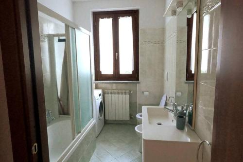 a bathroom with a sink and a shower and a toilet at Hygge Holiday House in Luino