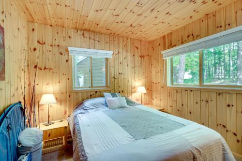 ein Schlafzimmer mit einem Bett in einer Holzwand in der Unterkunft Detroit Lakes Cabin Rental on Long Lake! in Detroit Lakes