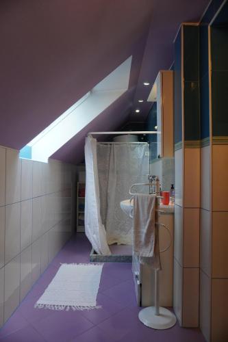 a bathroom with purple flooring and a sink with a towel at Koča Kopriva in Križe