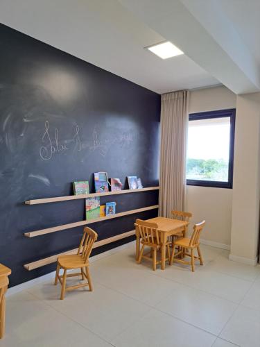 une salle de classe avec une table, des chaises et un tableau noir dans l'établissement Guarajuba Paraiso dos Coqueiros B02, à Camaçari