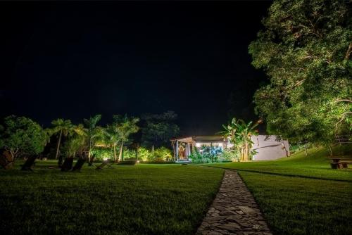 a house lit up at night with a walkway at El Rio Hotel in Doradal