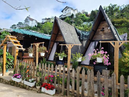 een klein huis met bloemen ervoor bij Cleverlearn's Homestay & Coffee in Ấp Ða Lợi