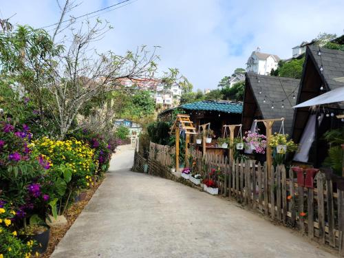 een tuinpad met bloemen en een hek bij Cleverlearn's Homestay & Coffee in Ấp Ða Lợi
