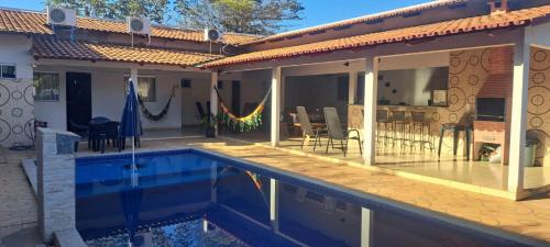 a house with a swimming pool and a patio at Rancho peixe grande in Sao Miguel do Araguaia