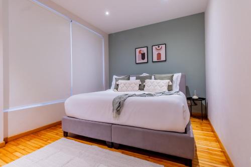 a bedroom with a large white bed in a room at Capitalia - Apartments - Juan Racine in Mexico City
