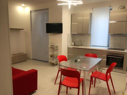 a kitchen with a dining table and red chairs at Casa Vacanze Il Divano Rosso in Foligno