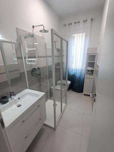 a white bathroom with a shower and a sink at Casa Vacanze Il Divano Rosso in Foligno