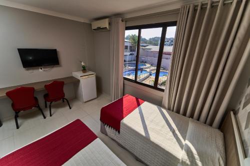 a bedroom with a bed and a view of a pool at Foz Plaza Hotel in Foz do Iguaçu