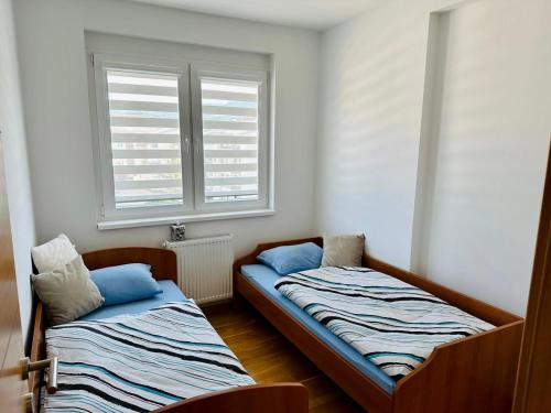dwa łóżka w pokoju z oknem w obiekcie Apartman Pale Jahorina w mieście Pale