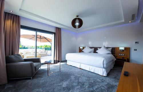 a hotel room with a bed and a couch and a bed at Villa HAW Marrakech in Marrakech