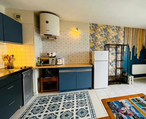 La cuisine est équipée de placards bleus et d'un réfrigérateur blanc. dans l'établissement Studio cosy 5 personnes, à Saint-Lary-Soulan