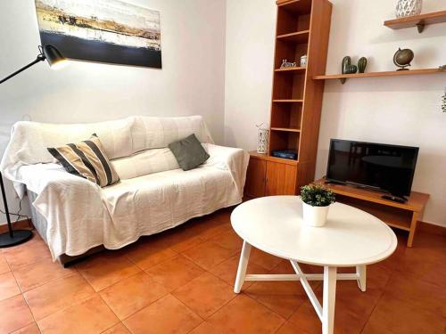 sala de estar con sofá blanco y mesa en Apartamento St Agustí - Centro, en Mataró