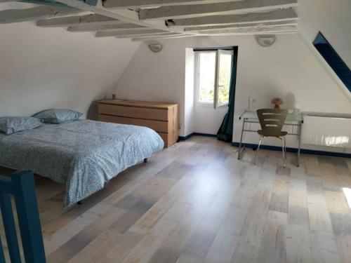 a bedroom with a bed and a desk and a window at maison en pierre chaleureuse in Jumilhac-le-Grand