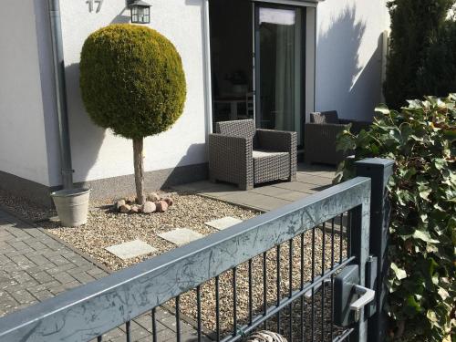 a fence in front of a house with a tree at Baltic Hus Zierow s Gem in Zierow