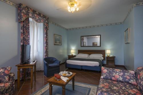 a hotel room with a bed and a couch at La Pineta Dei Liberti in Lido dei Pini