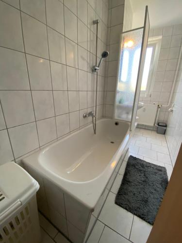 een witte badkamer met een bad en een wastafel bij Monteur und Ferienwohnung THMS 14 R 