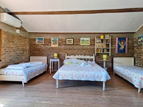 a bedroom with two beds and a brick wall at Casas lindas no paraiso! in Costa Dourada