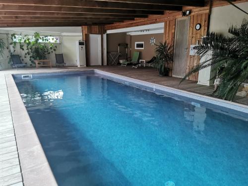 une grande piscine avec de l'eau bleue dans l'établissement Au grès des Vosges, à Remoneix