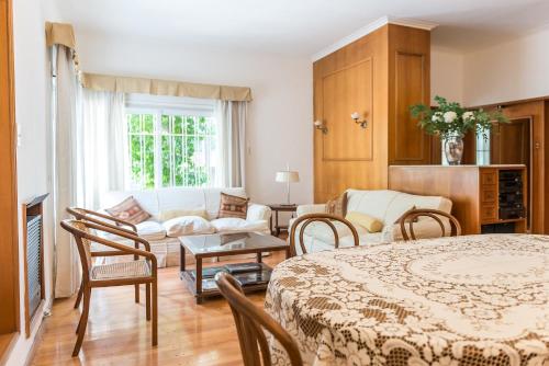 1 dormitorio con 1 cama y sala de estar con sofá en Casa Magnolia by Vilvey Turismo en Mendoza