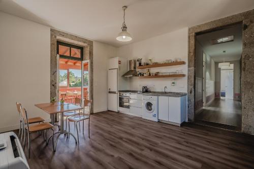 a kitchen and dining room with a table and a table and chairs at Quinta Calheiros - Rural Place in Coucieiro