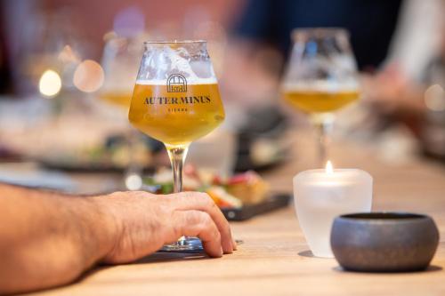two glasses of beer on a table with a candle at Hôtel Au Terminus in Sierre
