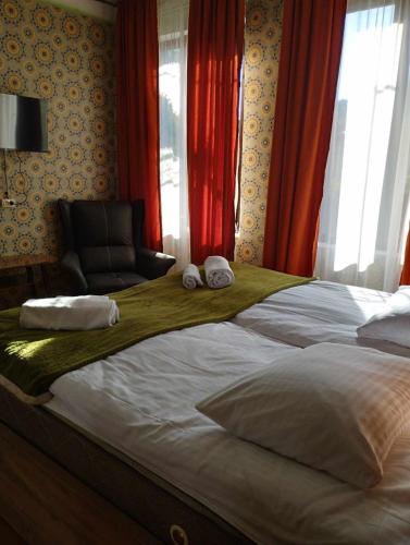 a bedroom with a large bed with a chair at GuestHouse Oni-Li in Oni