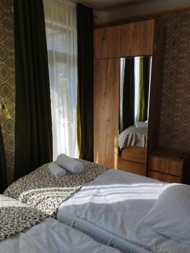 1 Schlafzimmer mit 2 Einzelbetten und einem Spiegel in der Unterkunft GuestHouse Oni-Li in Oni