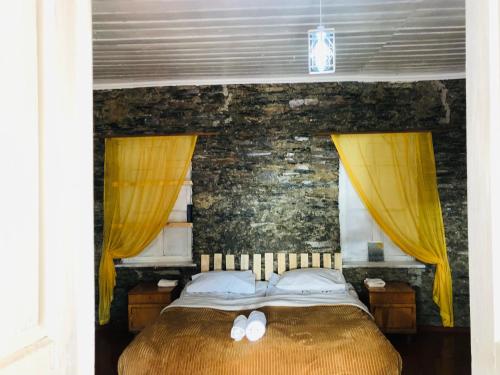 a bedroom with a bed with yellow drapes at Ela in Ushguli