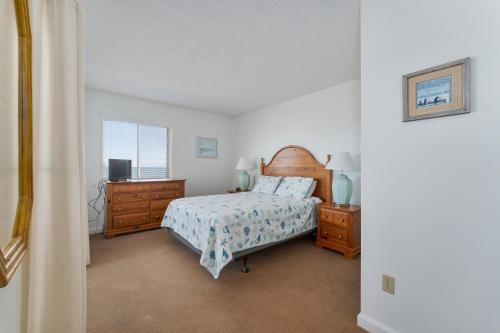 a bedroom with a bed and two dressers and a window at 7055 - Hatteras High 8C by Resort Realty in Rodanthe