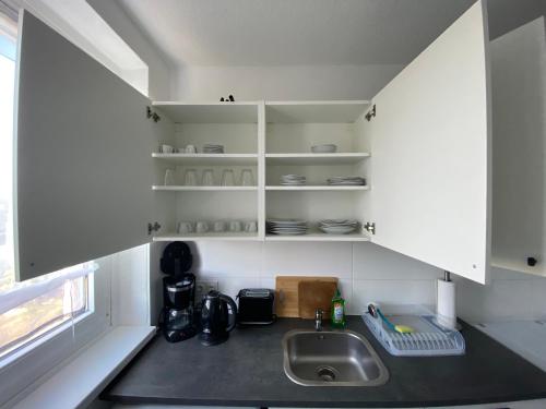 a kitchen with white cabinets and a sink at Monteurwohnung und Ferienwohnung TMS 18 O in Wefensleben