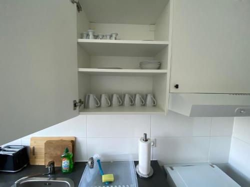 a kitchen with white cabinets and a sink at Monteurwohnung und Ferienwohnung TMS 18 O in Wefensleben