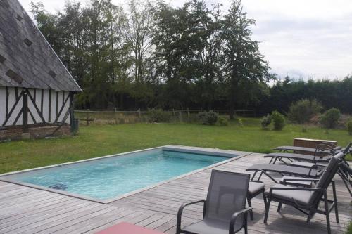 una piscina en una terraza con sillas y un patio en Maison entière avec piscine chauffée 4p, en Brétigny