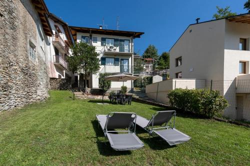 - deux chaises longues dans la cour d'une maison dans l'établissement Elegant Home - Panorama del Gran Paradiso con Giardino, à Alpette