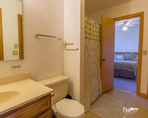 La salle de bains est pourvue de toilettes, d'un lavabo et d'un miroir. dans l'établissement 7102 - Sweet Haven by Resort Realty, à Waves