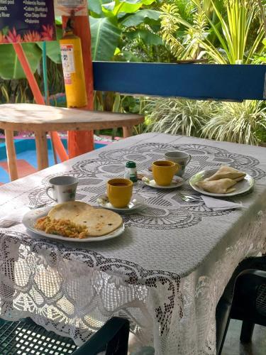 a table with plates of food and cups on it at Eco-Cafe El Mirador in Guachaca
