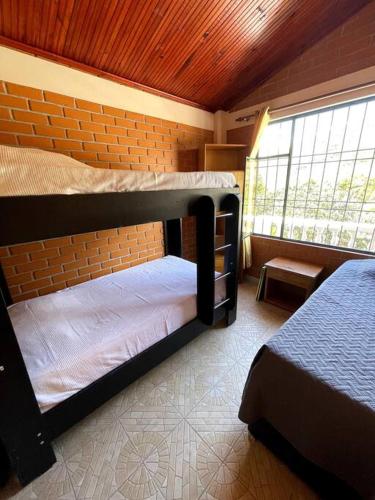 a bedroom with two bunk beds and a window at Hermosa y lujosa cabaña familiar in Chachagüí