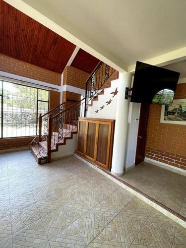 a room with a staircase in a building with a hallway at Hermosa y lujosa cabaña familiar in Chachagüí