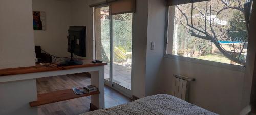 a bedroom with a bed and a large window at Pequeña casa en chacras de coria in Chacras de Coria
