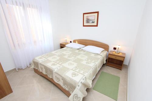 a small bedroom with a bed and two night stands at Apartments Luna in Rovinj