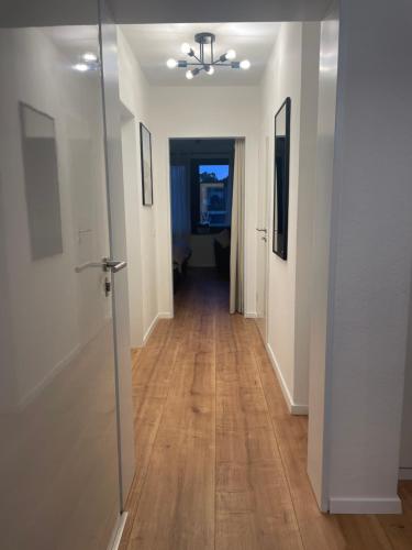 a hallway with white walls and a hard wood floor at Ferienwohnung Dortmund - Elias - Adults Only in Dortmund