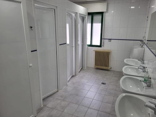 uma casa de banho com três lavatórios e três WC em Albergue de Villamanín em Villamanín