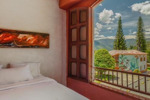 a bedroom with a bed and a window with a view at Granja del Cafe Hotel y Centro de convenciones in Venecia