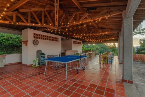 a patio with a ping pong table and chairs at Granja del Cafe Hotel y Centro de convenciones in Venecia
