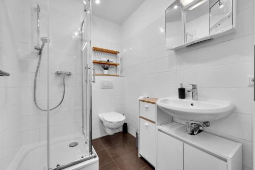 ein weißes Bad mit einem Waschbecken und einer Dusche in der Unterkunft Wohnung im Herzen Münchens nähe Hauptbahnhof in München